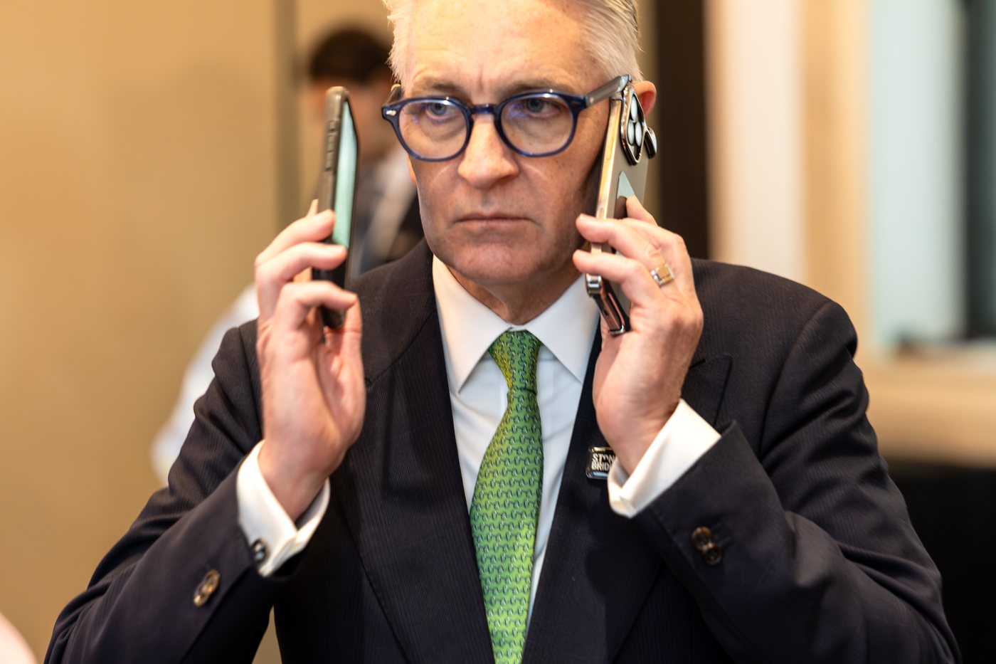Left: paddle fifteen, in. Right: an agent on two phones at once — the shot that says more about how this business works than any wide ever could.